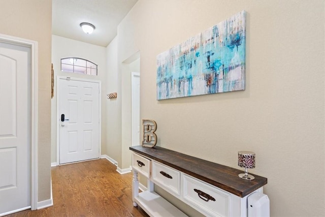 entryway with baseboards and wood finished floors