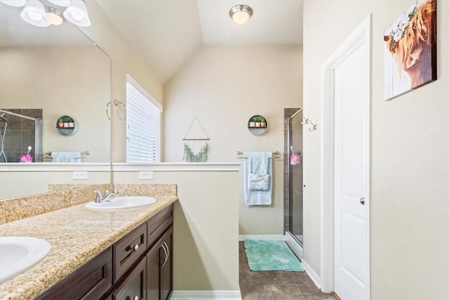 bathroom with double vanity, a stall shower, a sink, and lofted ceiling