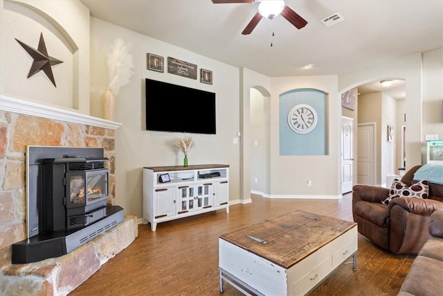 living area with baseboards, visible vents, a ceiling fan, arched walkways, and wood finished floors