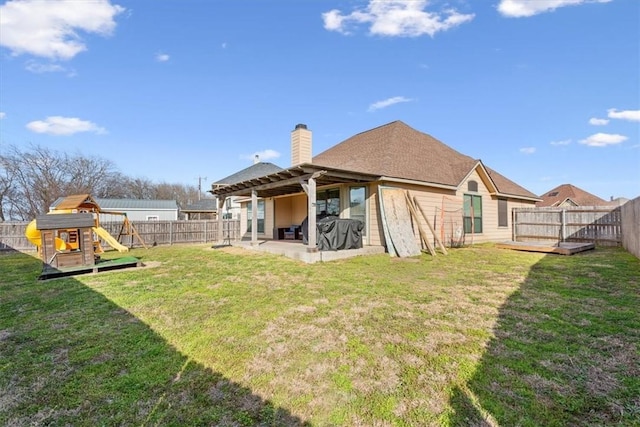 back of house featuring a patio, a fenced backyard, a chimney, a yard, and a playground