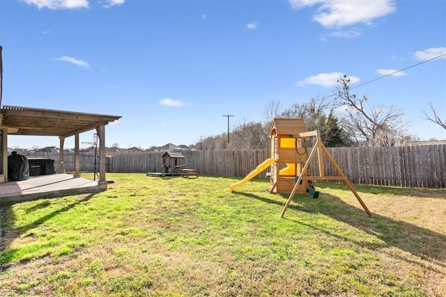 view of yard featuring a patio area, a fenced backyard, and a playground