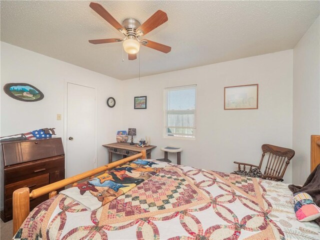 bedroom with ceiling fan and a textured ceiling