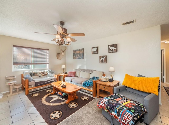 living room featuring ceiling fan, light tile patterned floors, and a textured ceiling