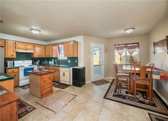 kitchen with sink, backsplash, a textured ceiling, white appliances, and light tile patterned flooring