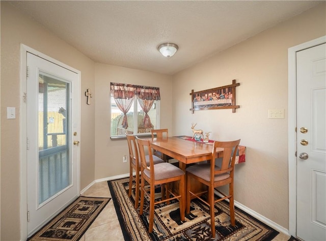 tiled dining space featuring a wealth of natural light and a textured ceiling