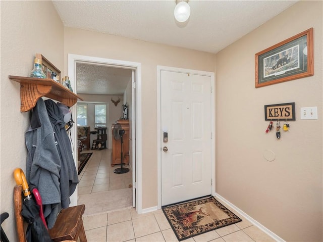 tiled foyer entrance featuring a textured ceiling