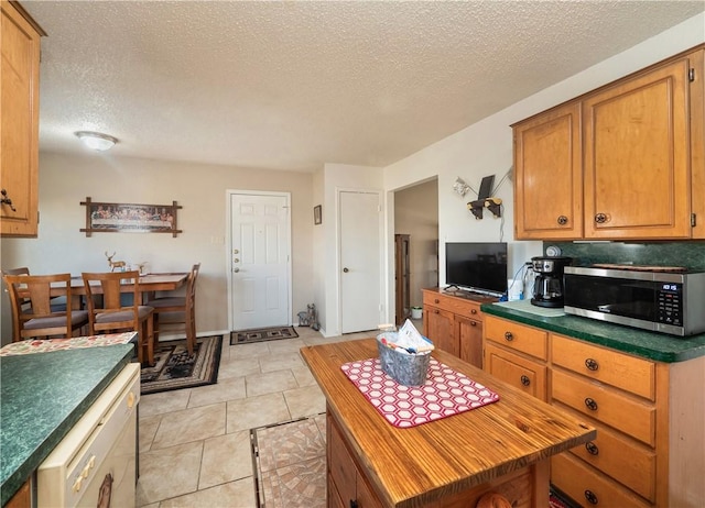 kitchen with a kitchen island, light tile patterned floors, and a textured ceiling