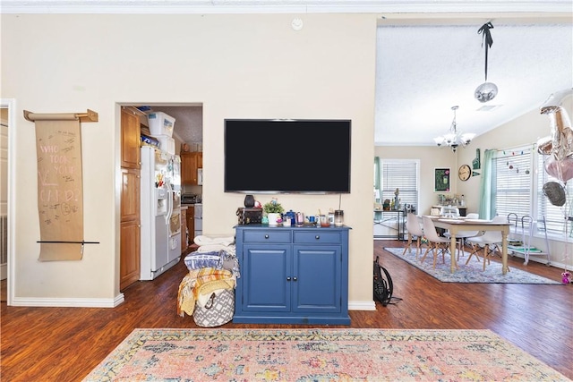 living room with baseboards, lofted ceiling, dark wood-style floors, ornamental molding, and a notable chandelier