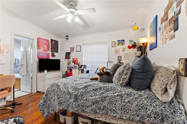 bedroom featuring lofted ceiling, a textured ceiling, a ceiling fan, and wood finished floors