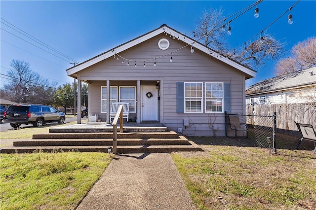 bungalow-style house featuring fence, a porch, and a front yard