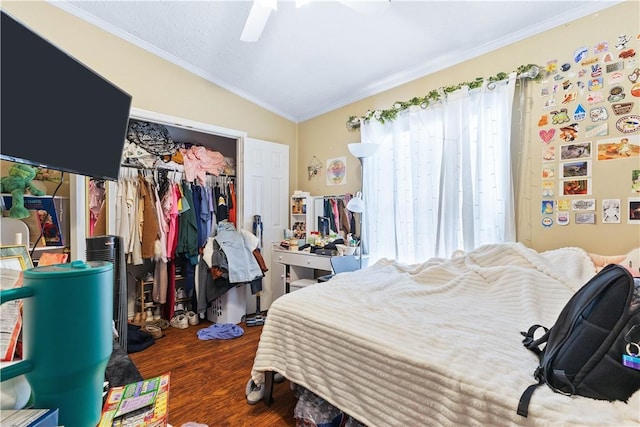 bedroom featuring dark wood-style floors, ornamental molding, multiple windows, and a closet