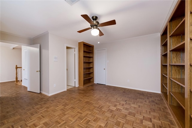 empty room with ceiling fan, ornamental molding, and parquet flooring