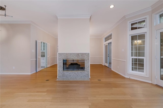 unfurnished living room featuring a fireplace, light wood-type flooring, and crown molding