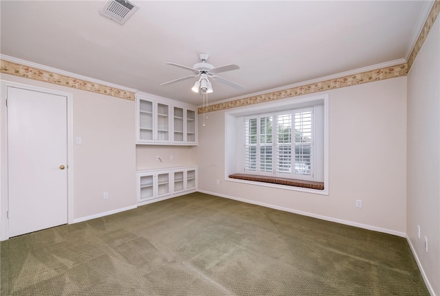 carpeted spare room featuring built in shelves, ceiling fan, and ornamental molding