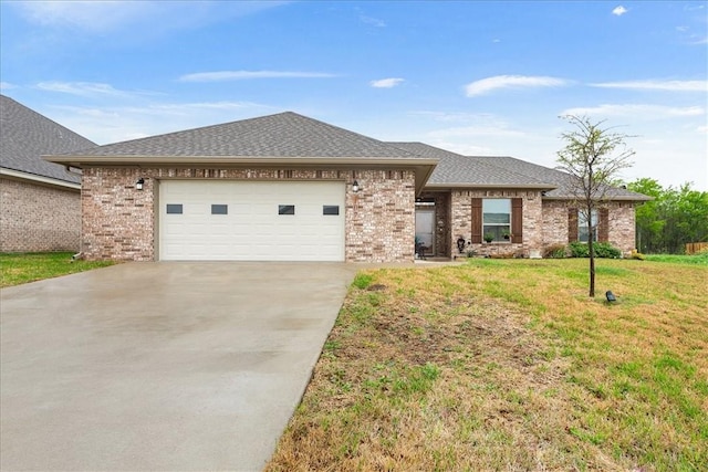 view of front of property with a garage, concrete driveway, roof with shingles, a front yard, and brick siding