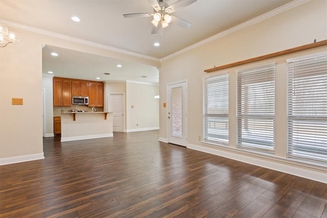 unfurnished living room featuring ornamental molding, baseboards, dark wood finished floors, and ceiling fan with notable chandelier