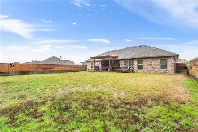 back of house featuring a fenced backyard, a pergola, a lawn, and brick siding