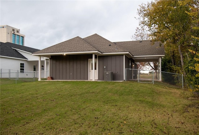 back of house with cooling unit and a lawn