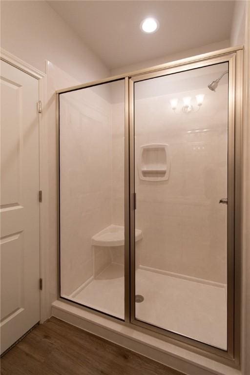 bathroom with wood-type flooring and a shower with door