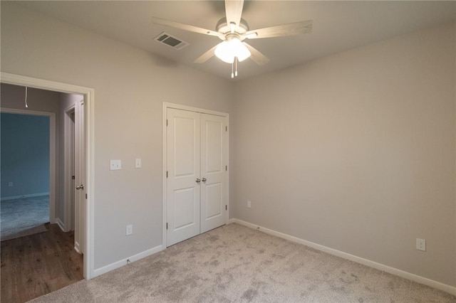 unfurnished bedroom featuring ceiling fan, light carpet, and a closet