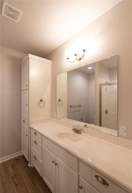 bathroom featuring vanity, a shower with door, and hardwood / wood-style floors