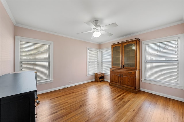 unfurnished bedroom featuring baseboards, a ceiling fan, crown molding, and light wood finished floors