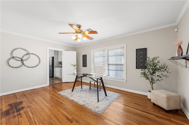 office space with light wood-style flooring, crown molding, and baseboards