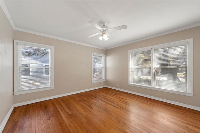 spare room with baseboards, light wood-style floors, ornamental molding, and a ceiling fan