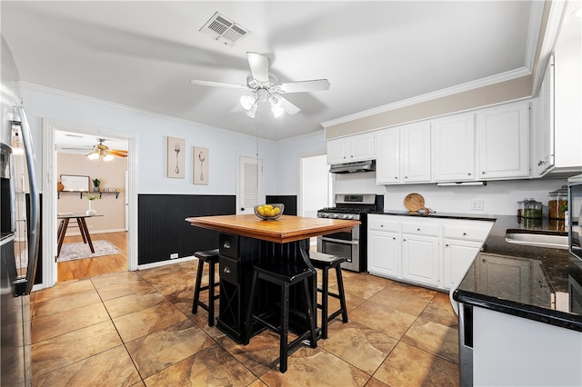 kitchen with visible vents, range with two ovens, ceiling fan, white cabinets, and under cabinet range hood