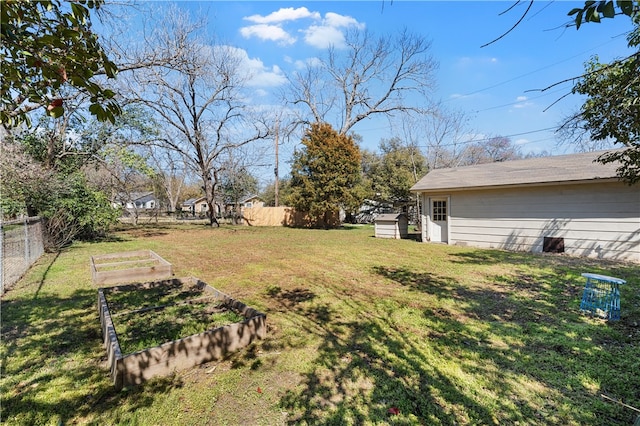 view of yard featuring a garden, an outdoor structure, and fence private yard