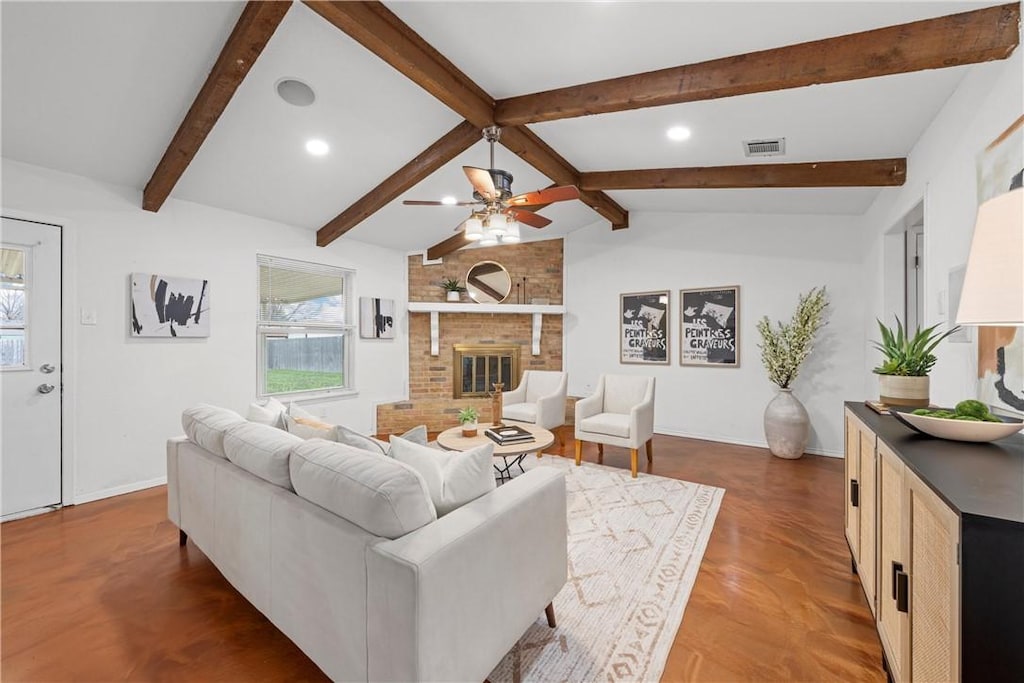 living room featuring vaulted ceiling with beams, wood-type flooring, a fireplace, and ceiling fan