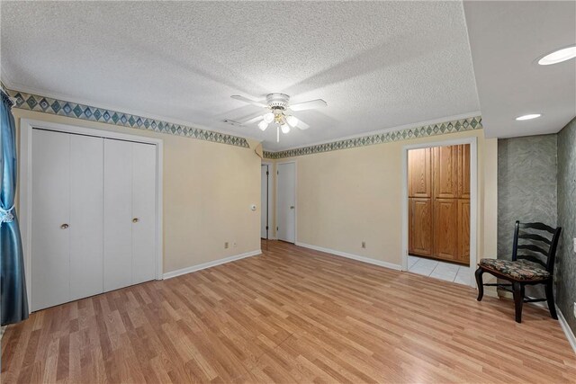 unfurnished bedroom with ceiling fan, crown molding, light hardwood / wood-style floors, and a textured ceiling