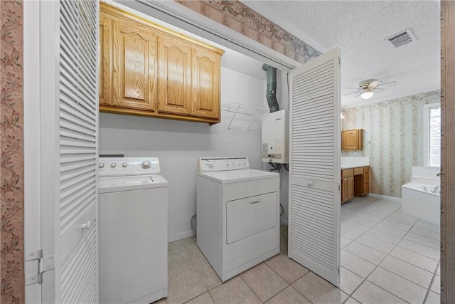 washroom with cabinets, a textured ceiling, ceiling fan, separate washer and dryer, and light tile patterned flooring