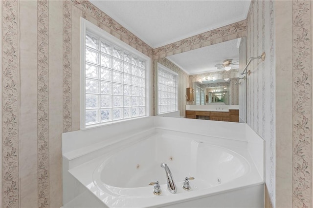 bathroom featuring a bath, a textured ceiling, and ornamental molding