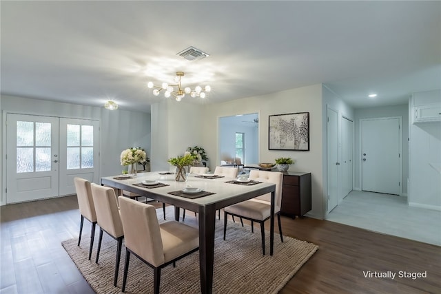 dining room featuring hardwood / wood-style floors, ceiling fan with notable chandelier, and french doors