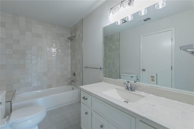 full bathroom featuring vanity, tiled shower / bath combo, and toilet