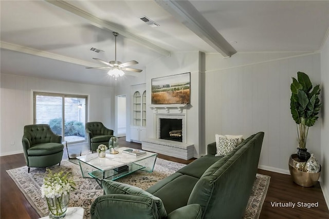 living room with lofted ceiling with beams, ceiling fan, dark hardwood / wood-style flooring, and a brick fireplace