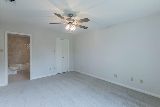 unfurnished bedroom with ceiling fan, light colored carpet, connected bathroom, and a closet