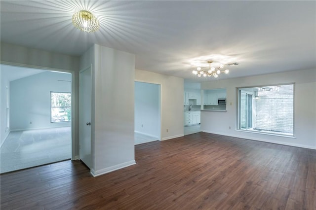 unfurnished living room with dark hardwood / wood-style floors and a chandelier