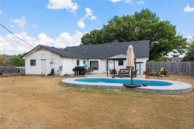 back of house featuring a fenced in pool, a gazebo, a yard, and a patio area