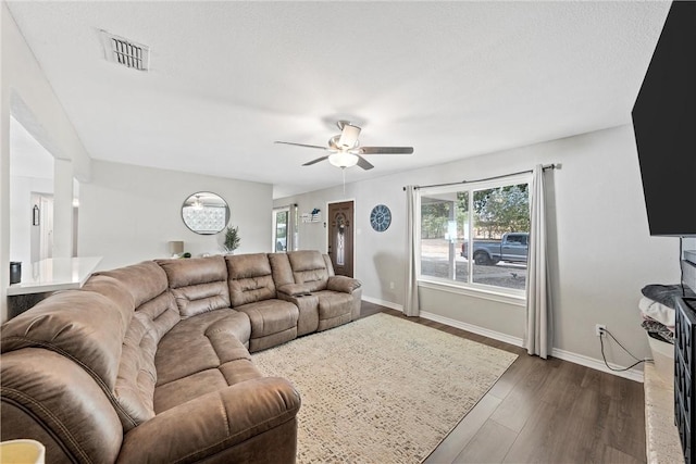 living room featuring ceiling fan and dark hardwood / wood-style flooring