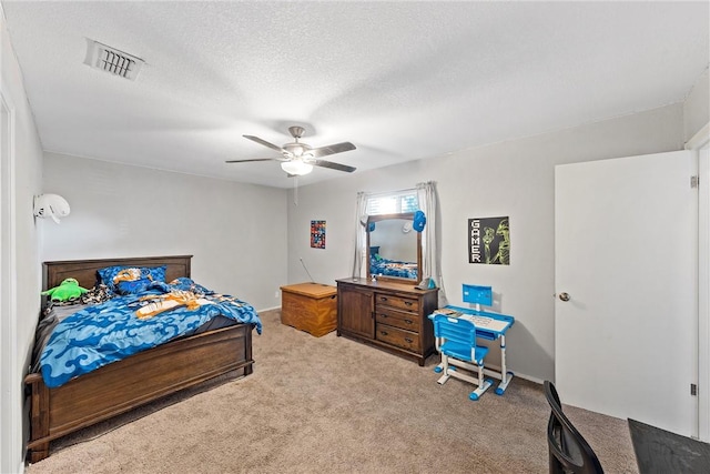 carpeted bedroom with ceiling fan and a textured ceiling