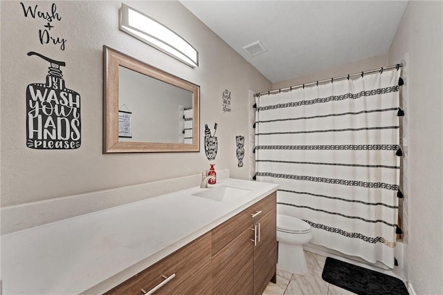 bathroom featuring vanity, walk in shower, and toilet