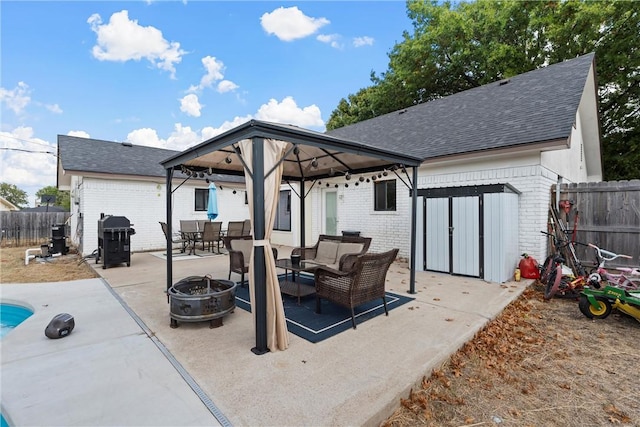 back of house with a gazebo, an outdoor living space with a fire pit, and a patio