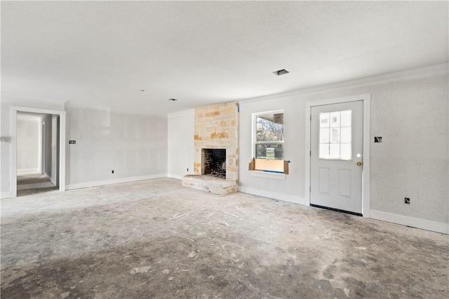 unfurnished living room featuring a textured ceiling and a stone fireplace