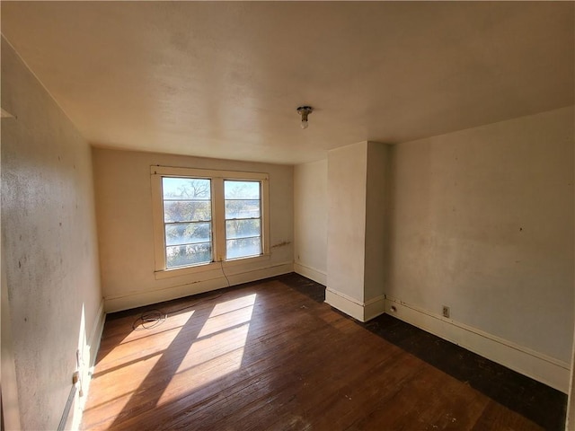 unfurnished room with dark hardwood / wood-style flooring