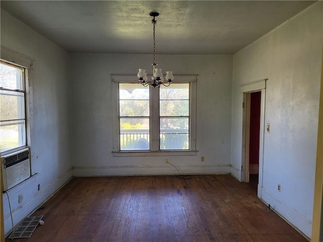 unfurnished dining area with plenty of natural light, dark hardwood / wood-style floors, and an inviting chandelier