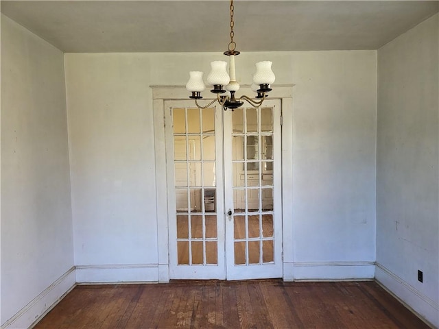 unfurnished dining area with dark hardwood / wood-style flooring and a notable chandelier