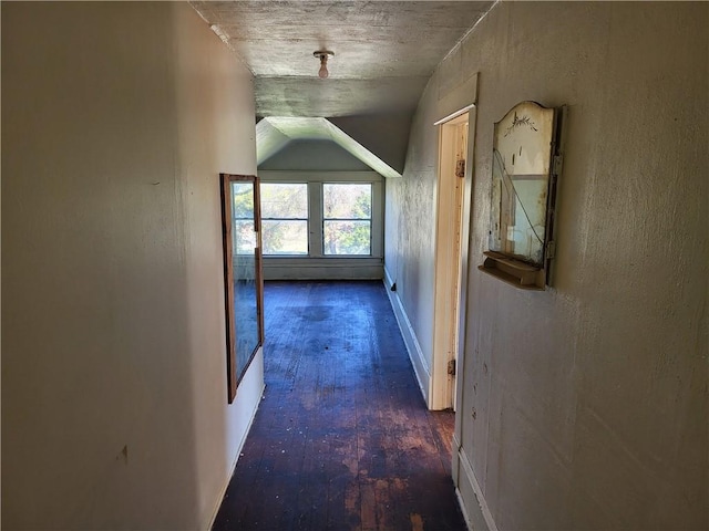 corridor with dark hardwood / wood-style flooring and vaulted ceiling