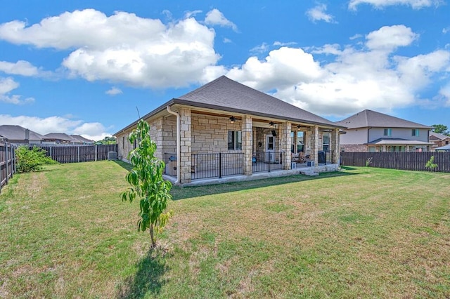 rear view of property with a lawn, a patio area, and ceiling fan